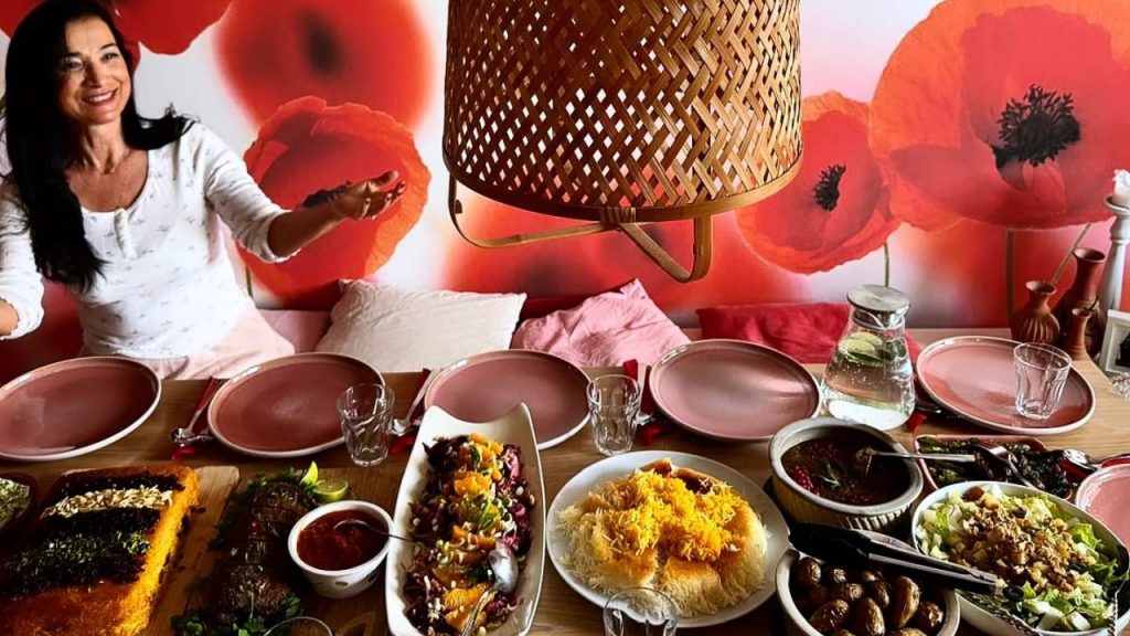 Persischer Kochkurs in Düsseldorf – verschiedene persische Gerichte wie Tahchin-e Morgh, Safranreis, Fesenjoun und Salate vor der Kochlehrerin, zubereitet im Kochkurs Mehmuni der Kochschule SAviña